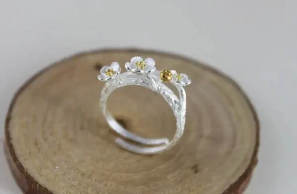 Sterling silver open ring featuring a branch with three gold-accented cherry blossoms.