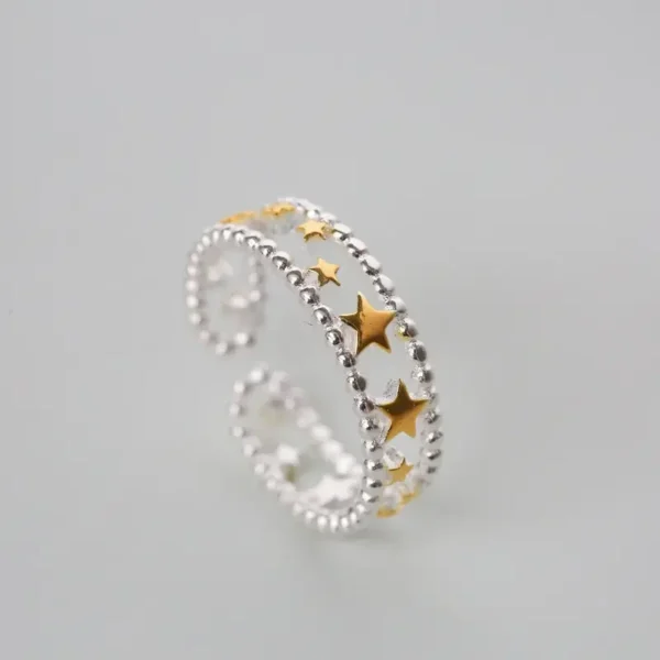 Sterling silver open ring with gold-plated stars arranged along a beaded band.