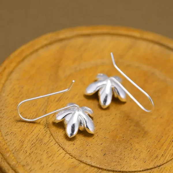 Sterling silver long flower earrings with gold accents.