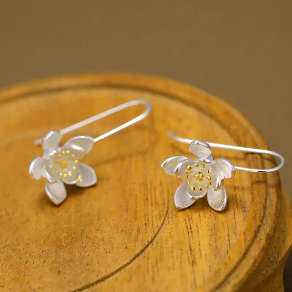 Sterling silver long flower earrings with gold accents.