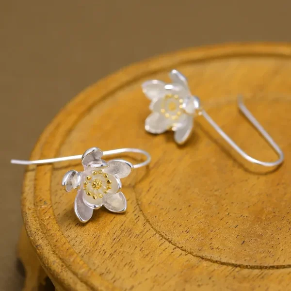 Sterling silver long flower earrings with gold accents.